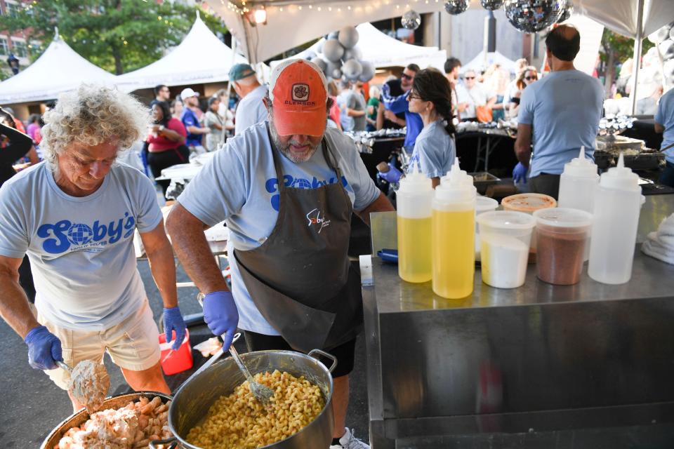 Talmadge Shirley and Greg Cope cook at Soby's Fall For Greenville tent on Saturday, Oct. 14, 2023 in downtown Greenville, S.C.
