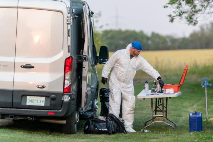 An investigator in protective equipment works at a crime scene in Weldon, Saskatchewan, on Sunday, Sept. 4, 2022 (The Canadian Press)