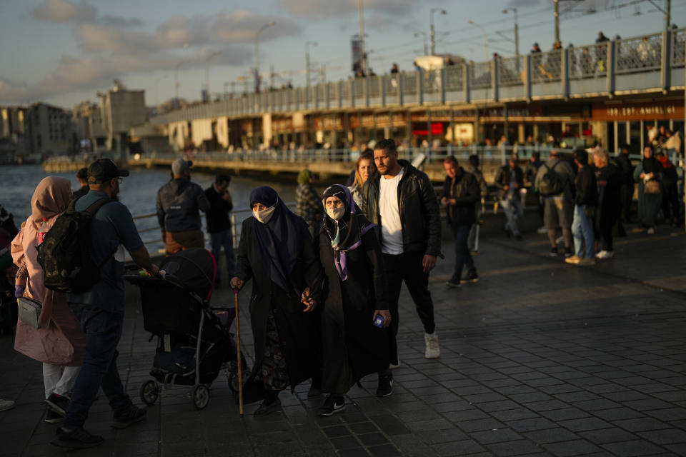 People walk near Galata bridge in Istanbul, Turkey, Tuesday, May 23, 2023. Two opposing visions for Turkey’s future are on the ballot when voters return to the polls Sunday for a runoff presidential election, which will decide between an increasingly authoritarian incumbent President Recep Tayyip Erdogan and challenger Kemal Kilicdaroglu, who has pledged to restore democracy. (AP Photo/Francisco Seco)