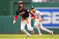 Washington Nationals' CJ Abrams, left, takes off from second base on his way to scoring as Houston Astros shortstop Jeremy Peña, back right, reacts after Nationals' Jesse Winker's RBI single to left field during the first inning of a baseball game at Nationals Park, Sunday, April 21, 2024, in Washington. (AP Photo/John McDonnell)