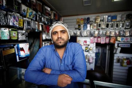 Rashid bin Ali al-Muqaladi, 29, who sells used mobile phones, poses for a photograph in Sanaa, Yemen, April 30, 2016. REUTERS/Mohamed al-Sayaghi