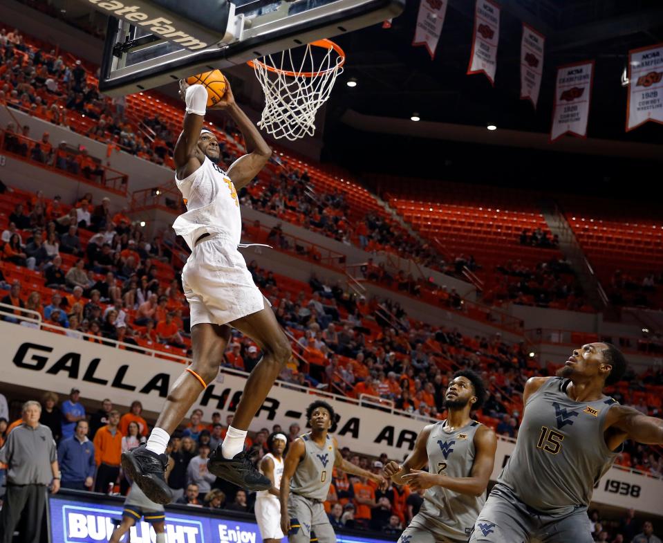 Oklahoma State's Moussa Cisse (33) dunks the ball in front of West Virginia's Kobe Johnson (2) and Jimmy Bell Jr. (15) in the first half during the college basketball game between Oklahoma State University Cowboys and the West Virginia Mountaineers at Gallagher-Iba Arena in Stillwater, Okla., Monday, Jan.2, 2023. OSU won 67-60.