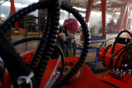 A woman works in the Tianye Tolian Heavy Industry Co. factory in Qinhuangdao in the QHD economic development zone, Hebei province, China December 2, 2016. REUTERS/Thomas Peter/File Photo GLOBAL BUSINESS WEEK AHEAD PACKAGE SEARCH BUSINESS WEEK AHEAD 12 DEC FOR ALL IMAGES