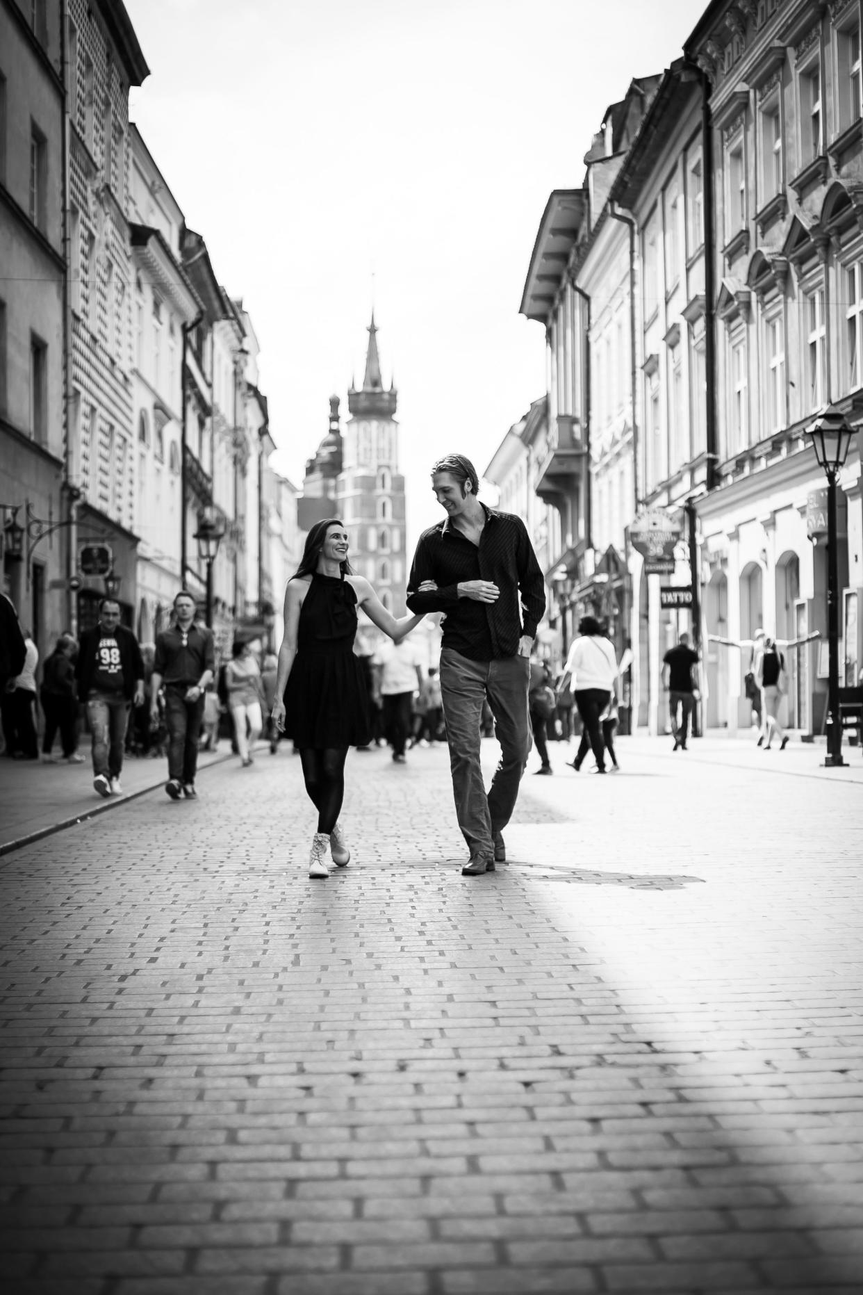 Husband and wife musical team Kin Curran and Drew De Four stroll down a street in Krakow, Poland. The couple will return Saturday, April 22, to the Tecumseh Center for the Arts stage.