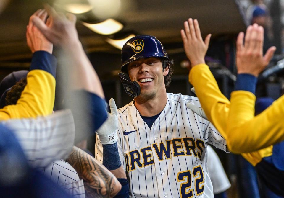 Oct 1, 2022; Milwaukee, Wisconsin, USA;  Milwaukee Brewers left fielder Christian Yelich (22) is greeted in the dugout after hitting a solo home run in the fourth inning against the Miami Marlins at American Family Field. Mandatory Credit: Benny Sieu-USA TODAY Sports