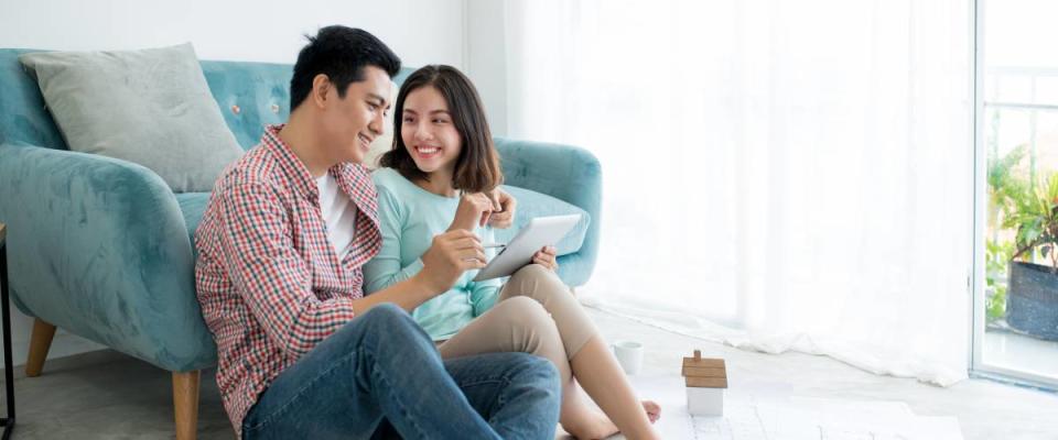 young couple discussing topic while looking at tablet computer