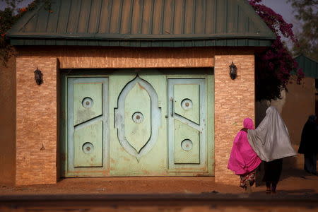 Two girls dressed in hijabs walk away from a house along the railway line in Zaria, in Kaduna state, Nigeria, February 2, 2016. REUTERS/Afolabi Sotunde