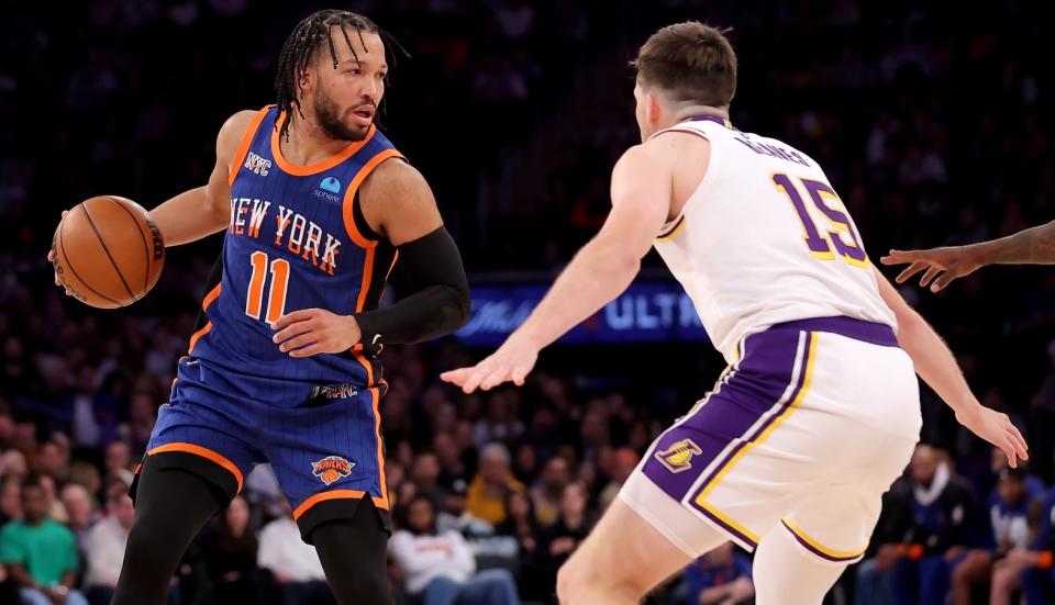 New York Knicks guard Jalen Brunson (11) controls the ball against Los Angeles Lakers guard Austin Reaves (15) during the fourth quarter at Madison Square Garden.