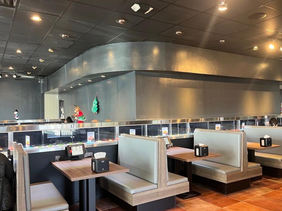 A conveyor belt with plates of food winds past each table at Rockin' Rolls Sushi Express at Cross Creek Mall in Fayetteville.