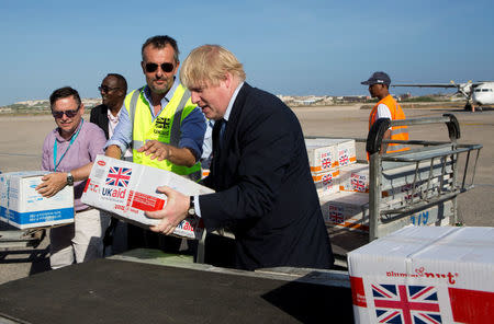 Britain's Foreign Secretary Boris Johnson (R) and UNICEF Somalia Country Director Steven Lauwerier help to load supplies for treating malnourished children affected by severe drought in Somalia onto a cargo plane at Mogadishu International Airport in Mogadishu, Somalia March 15, 2017. REUTERS/Karel Prinsloo/UNICEF/Handout via REUTERS