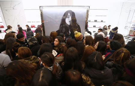 Bargain hunters crowd around the Saint Laurent handbag stall at Selfridges department store on the first day of their sales, in central London December 26, 2014. REUTERS/Andrew Winning