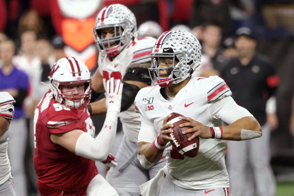 Ohio State quarterback Justin Fields, right, looks for a receiver during the second half of the team's Big Ten championship NCAA college football game against Wisconsin, Saturday, Dec. 7, 2019, in Indianapolis. (AP Photo/AJ Mast)