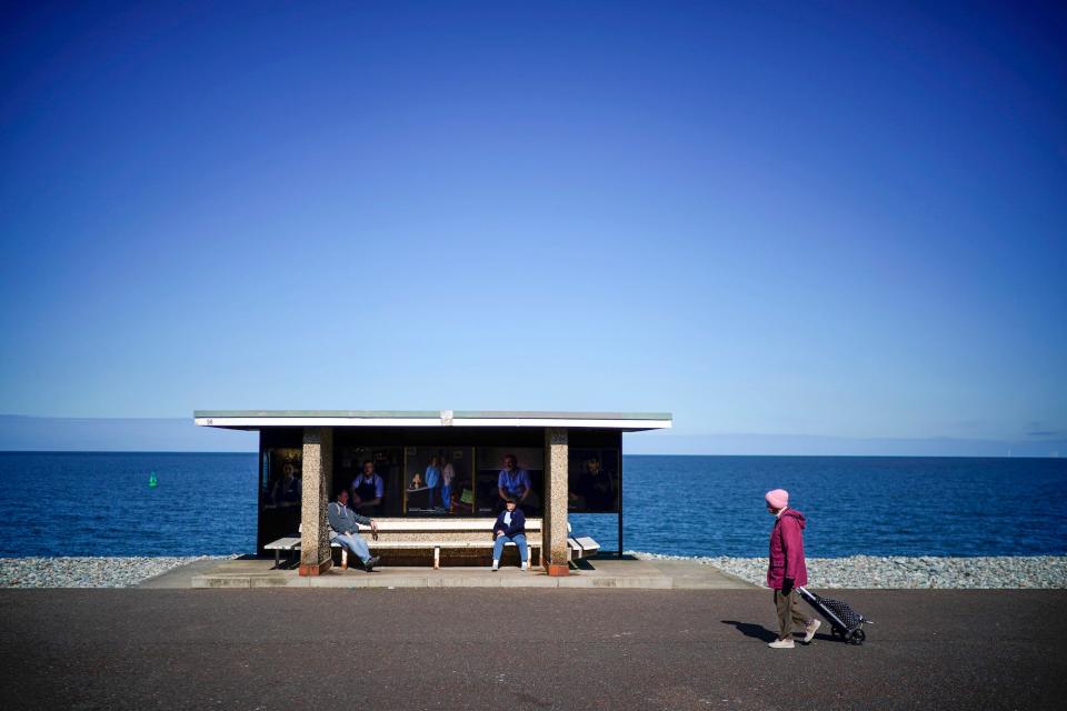 People practice social distancing on the near deserted promenade during the pandemic lockdown on March 31, 2020 in Llandudno