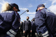 French President Emmanuel Macron speaks with French police officers during a visit on the strengthening border controls at the crossing between Spain and France, at Le Perthus, France, Thursday, Nov. 5, 2020. (Guillaume Horcajuelo, Pool via AP)