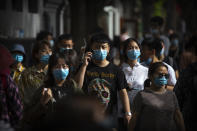 People wearing face masks to protect against the spread of the new coronavirus walk along a pedestrian shopping street in Beijing, Saturday, May 16, 2020. According to official data released on Saturday India's confirmed coronavirus cases have surpassed China's. (AP Photo/Mark Schiefelbein)