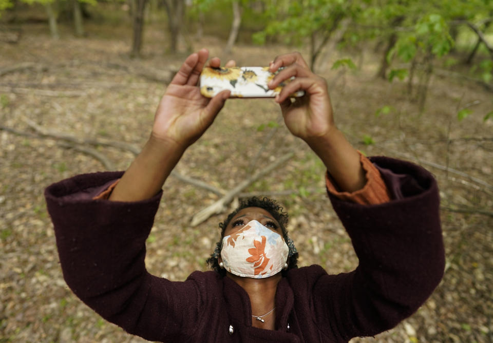 Trinadee Jenkins photographs the canopy in a wooded area to gather data for an undergraduate class project to measure urban heat island effects on time and density of cicada emergence, Thursday, April 22, 2021, near the University of Maryland Campus, in College Park, Md. (AP Photo/Carolyn Kaster)