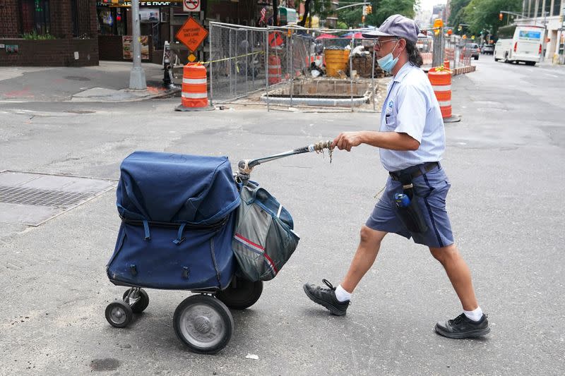 FILE PHOTO: USPS worker walks with his cart in New York City