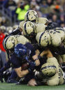 Navy fullback Alex Tecza is gang tackled by Army defenders during the second quarter of an NCAA football game at Gillette Stadium Saturday, Dec. 9, 2023, in Foxborough, Mass. (AP Photo/Winslow Townson)