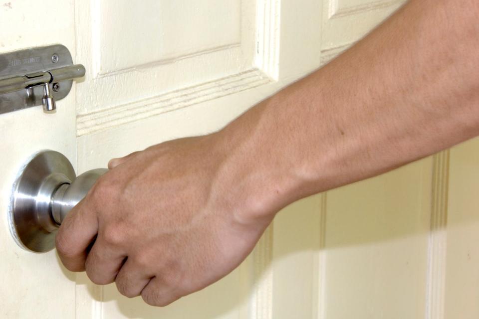 Person turning knob on an exterior door