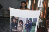Jennifer McDonald holds a blanket on which is printed photos of her late son, Demontravis Davonte Reid, who was shot and killed in Charlotte, N.C on April 14, 2021. As of July 15, he was among the 56 homicide victims in North Carolina's largest city. Homicide rates in many American cities have continued to rise although not as precipitously as the double-digit jumps seen in 2020 and still below the violence of the mid-90s. (AP Photo/Skip Foreman)