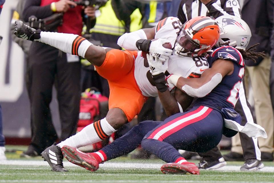 Cleveland Browns tight end David Njoku (85) hangs onto the ball as New England Patriots safety Kyle Dugger (23) makes the tackle during the first half of an NFL football game, Sunday, Nov. 14, 2021, in Foxborough, Mass. (AP Photo/Steven Senne)