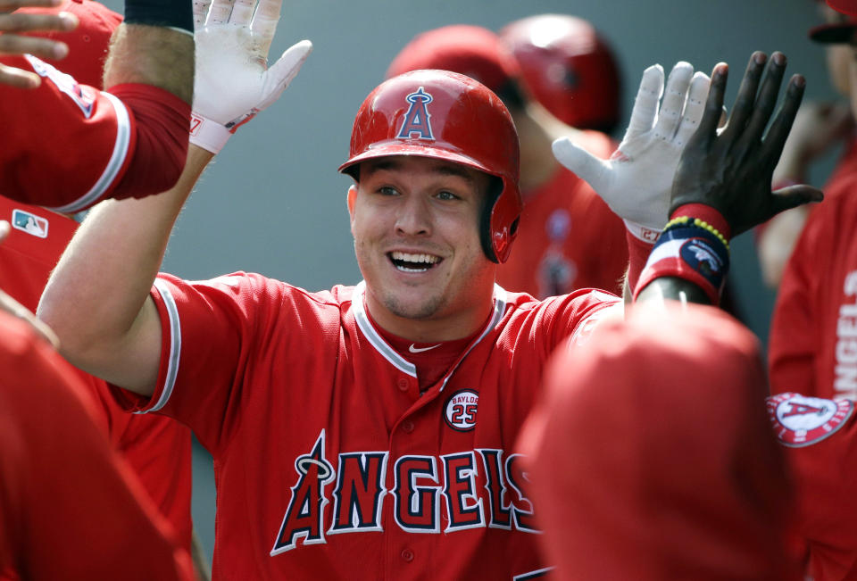 FILE - In this Sept. 10, 2017, file photo, Los Angeles Angels' Mike Trout is greeted in the dugout after hitting a solo home run in the first inning of a baseball game against the Seattle Mariners in Seattle. A person familiar with the negotiations tells The Associated Press Tuesday, March 19, 2019, that Trout and the Angels are close to finalizing a record $432 million, 12-year contract that would shatter the record for the largest deal in North American sports history. (AP Photo/Ted S. Warren, File)