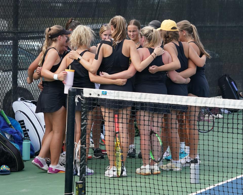 The Adrian College women's tennis team huddles up prior to a dual against Huntington.