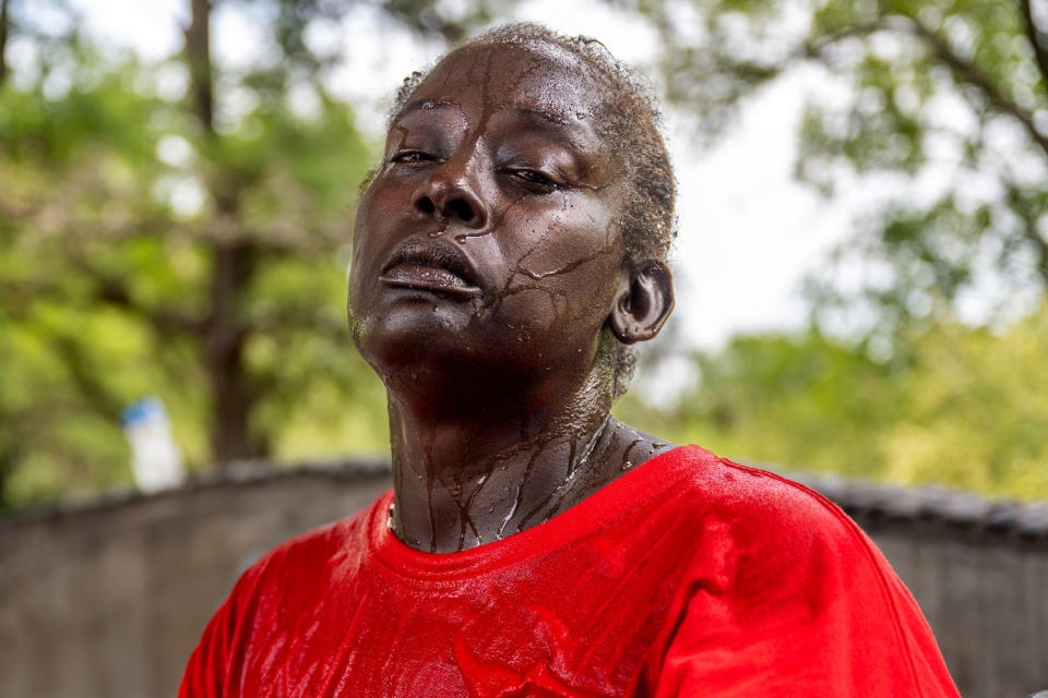 Image: Andrea Washington cries while speaking about the extreme heat and her health after pouring water on herself during record-breaking temperatures in Austin on July 11. (Brandon Bell / Getty Images file)