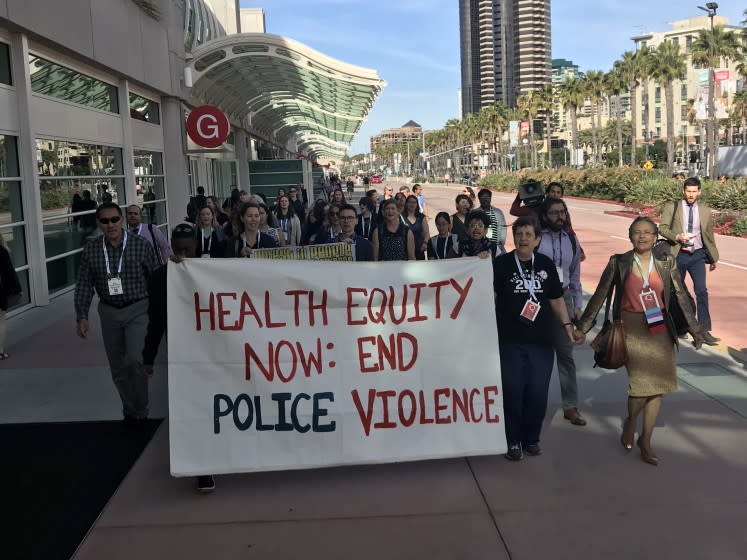 Attendees at a public health meeting protest police violence