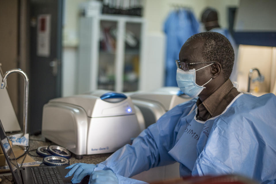 In this photo taken Friday, June 19, 2020, laboratory supervisor Simon Deng Nyichar enters data for patient samples at the country's only laboratory that tests for the coronavirus in Juba, South Sudan. The United Nations says the country's outbreak is growing rapidly, with nearly 1,900 cases, including more than 50 health workers infected, and at the only laboratory in the country that tests for the virus a team of 16 works up to 16-hour days slogging through a backlog of more than 5,000 tests. (AP Photo/Charles Atiki Lomodong)