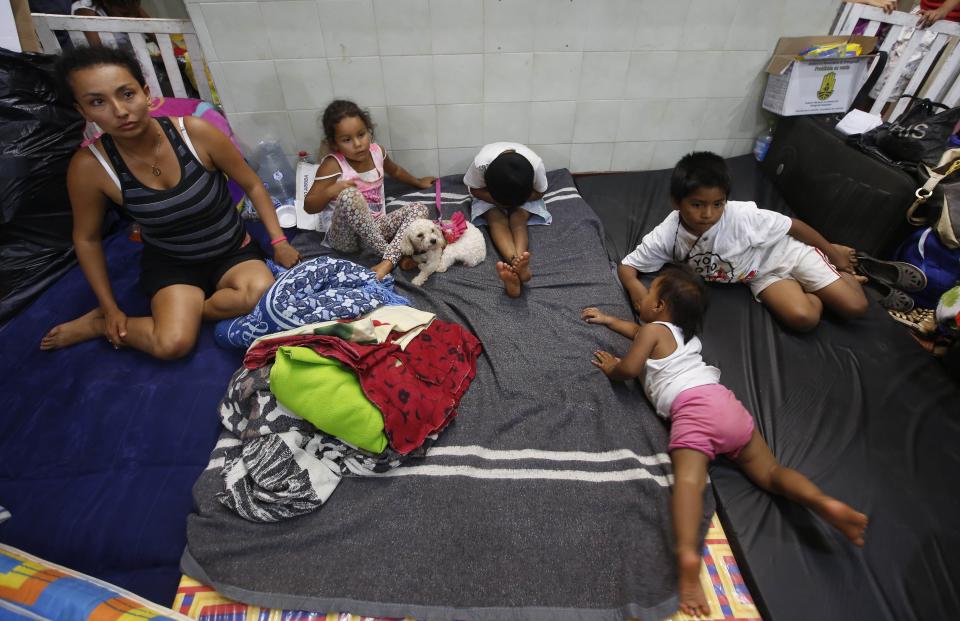 Una familia se instala en un refugio en Mocoa, Colombia, el domingo 2 de abril de 2017. Los ciudadanos buscan en sus hogares arruinados y en el hospital local a sus seres queridos después de que un torrente de agua, barro y escombros barrió Mocoa. Más de 200 personas han muerto. (AP Foto/Fernando Vergara)