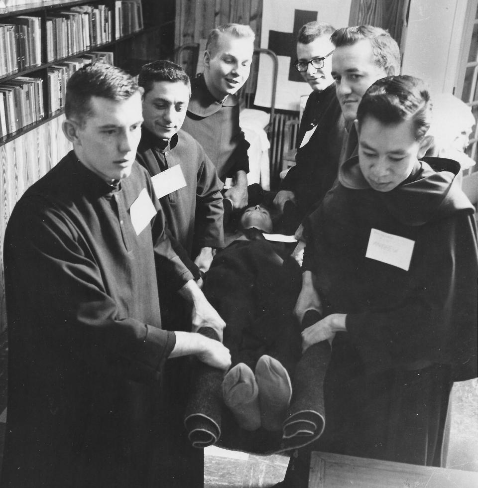 Brothers Terrance, Mark, Alexis, Dominic, Alphonsus and Andrew carry Brother Titus in a stretcher improvised from a blanket during first aid training in 1958 at the Infant of Prague Villa in Coventry Township.