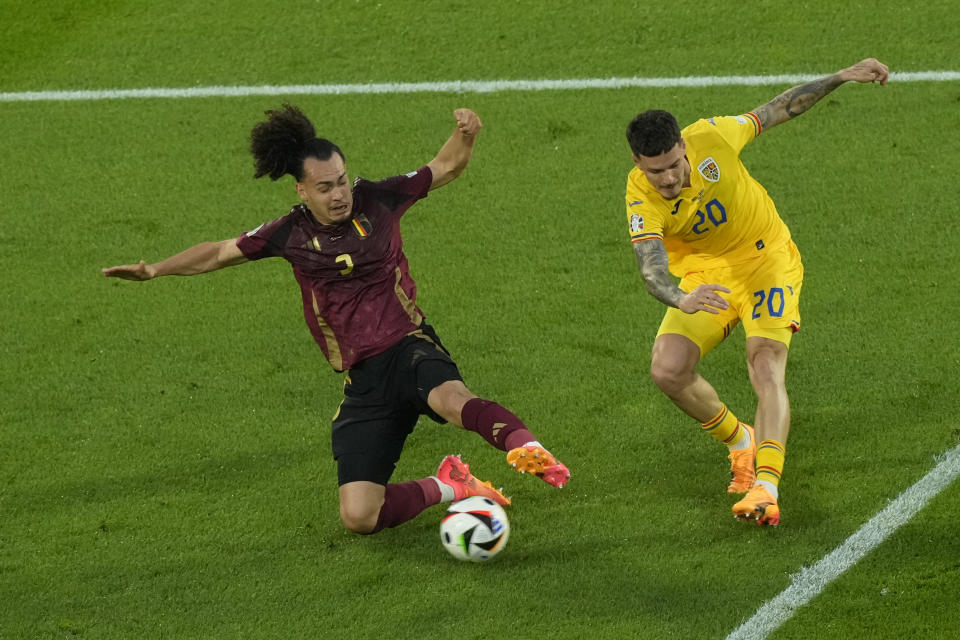 Romania's Dennis Man kicks past Belgium's Arthur Theateduring a Group E match between Belgium and Romania at the Euro 2024 soccer tournament in Cologne, Germany, Saturday, June 22, 2024. (AP Photo/Frank Augstein)