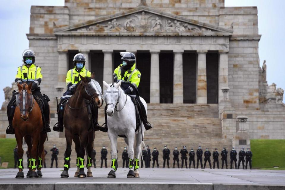 Police stand guard in front of the Shrine of Remembrance during an anti-lockdown rally in Melbourne