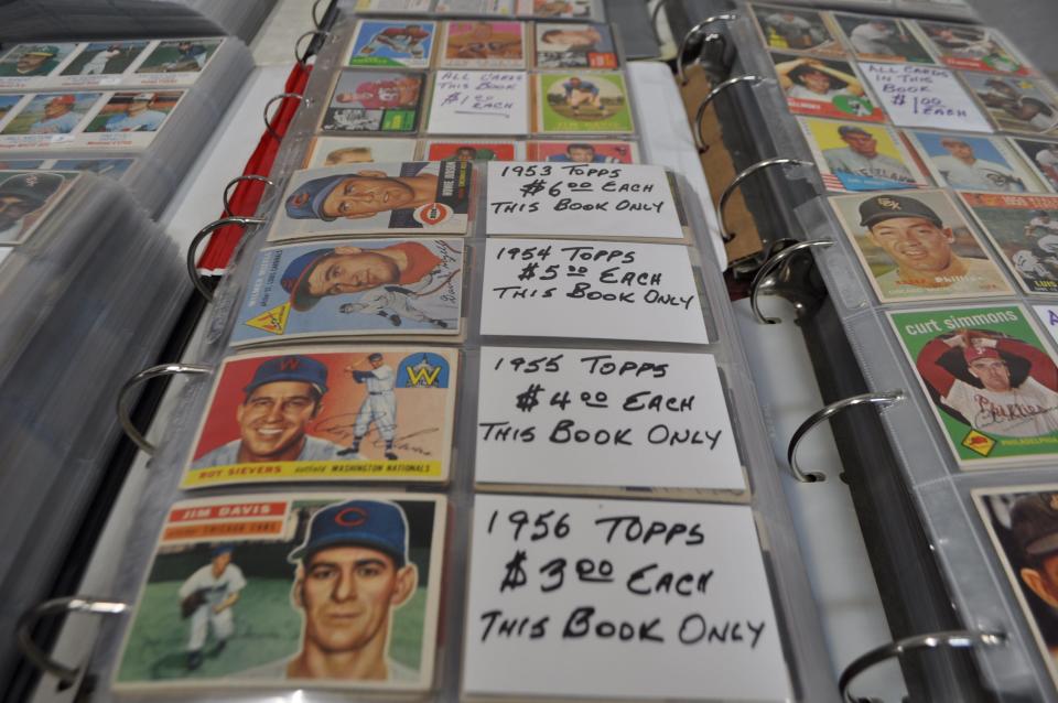 Baseball-card collectors trying to build complete sets of Topps cards from the 1950s spend hours picking from binders such as these at the Columbus Sports Card Show.