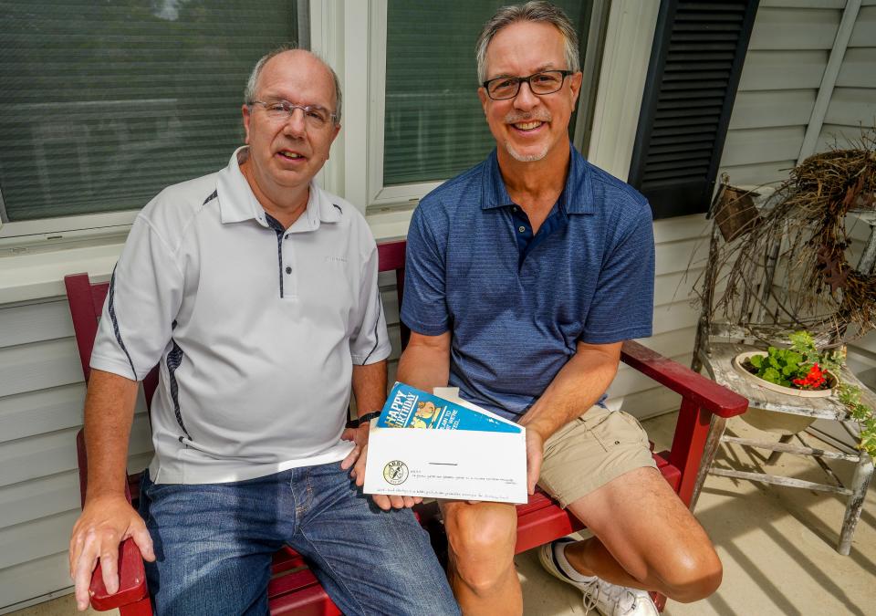 Steve Mathwig (left) and Karl Freund sit on the porch where their shared birthday card is delivered every year on July 19th (Freund's birthday).