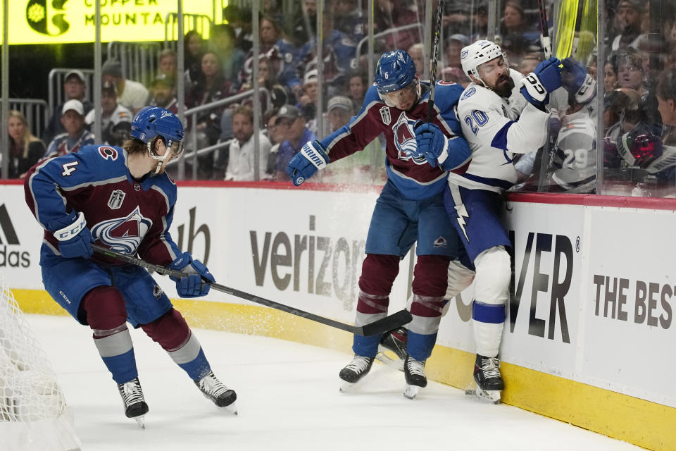 Tampa Bay Lightning left wing Nicholas Paul, right, collides with Colorado Avalanche defenseman Erik Johnson, center, during the third period of Game 1 of the NHL hockey Stanley Cup Final on Wednesday, June 15, 2022, in Denver. (AP Photo/John Locher)