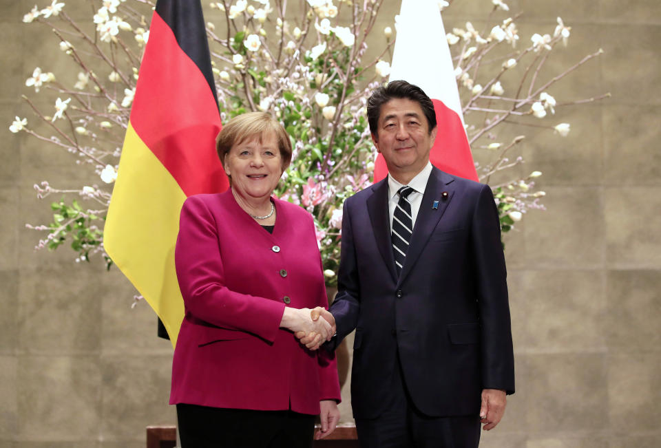 German Chancellor Angela Merkel, left, is welcomed by Japanese Prime Minister Shinzo Abe upon her arrival at Abe's official residence in Tokyo, Japan, Monday, Feb. 4, 2019. (Franck Robichon/Pool Photo via AP)