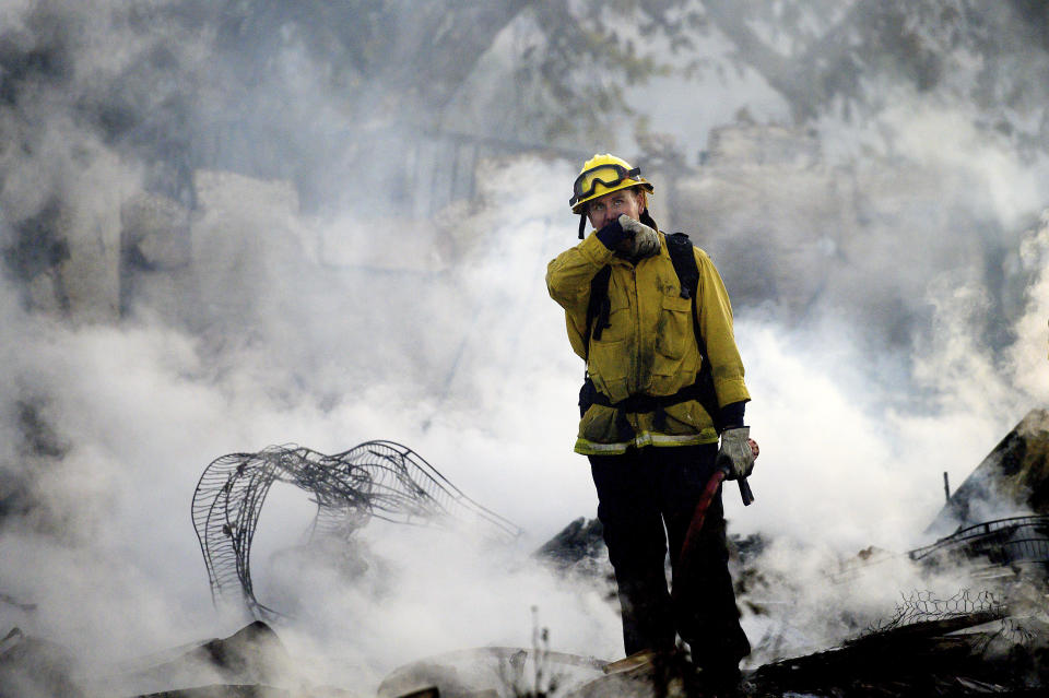 A firefighter pauses while mopping up at a leveled home as the Hillside Fire burns in San Bernardino, Calif., on Thursday, Oct. 31, 2019. The blaze, which ignited during red flag fire danger warnings, destroyed multiple residences. (AP Photo/Noah Berger)