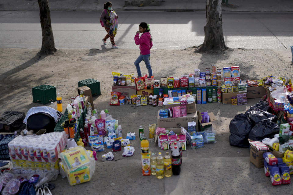 Los peatones pasan frente a un mercado al aire libre donde la gente puede comprar o intercambiar productos en las afueras de Buenos Aires, Argentina, el miércoles 10 de agosto de 2022. (AP Foto/Natacha Pisarenko)