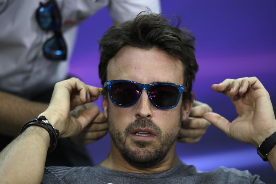 McLaren driver Fernando Alonso of Spain adjusts his earphone before the start of a news conference ahead the Bahrain Formula One Grand Prix at the Formula One Bahrain International Circuit in Sakhir, Bahrain, Thursday, April 13, 2017. The Bahrain Formula One Grand Prix will take place on Sunday. (AP Photo/Hassan Ammar)