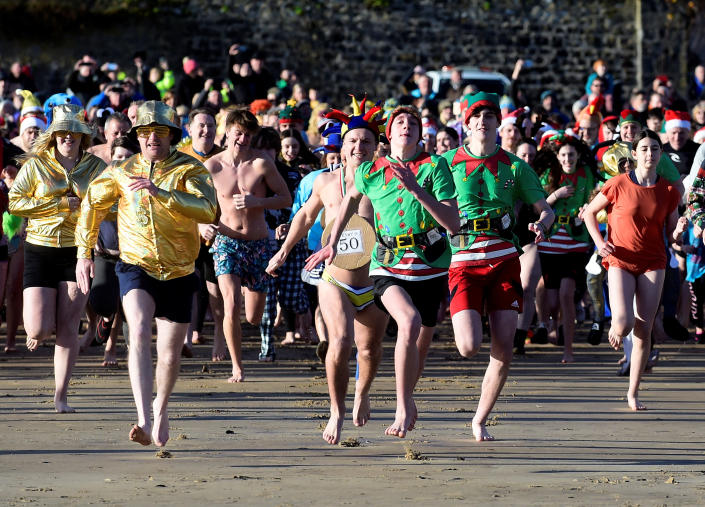 Participants run at the start of the 50th Boxing Day sea swim at Tenby, Wales, Britain, December 26, 2022. REUTERS/Rebecca Naden