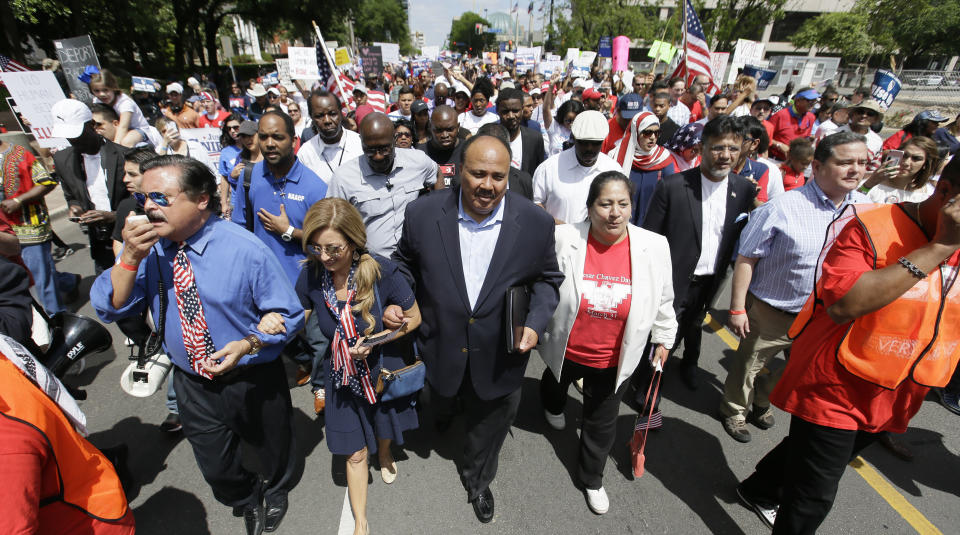 Martin Luther King III, center, helps lead a protest march with other activists through downtown Dallas, Sunday, April 9, 2017. Thousands of people are marching and rallying in downtown Dallas to call for an overhaul of the nation's immigration system and end to what organizers say is an aggressive deportation policy. (AP Photo/LM Otero)