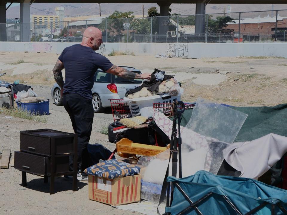 Grant Denton, founder of Karma Box, cleans up garbage at a homeless encampment in Reno, Nevada, on Aug. 7. The Nevada Cares Safe Camp model for a sanctioned homeless camp was considered a favorite of Salt Lake City leaders in April, shortly after they visited it. KSL.com visited the Reno camp last month to see how it works and what might be replicated in Utah.