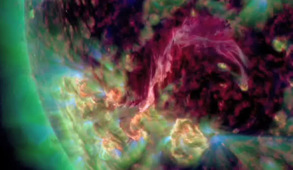 Un filamento de color rosado-púrpura de plasma caliente conecta dos manchas solares en esta vista ultravioleta registrada por la nave espacial del Observatorio de Dinámica Solar de la NASA el 4 de agosto de 2012.