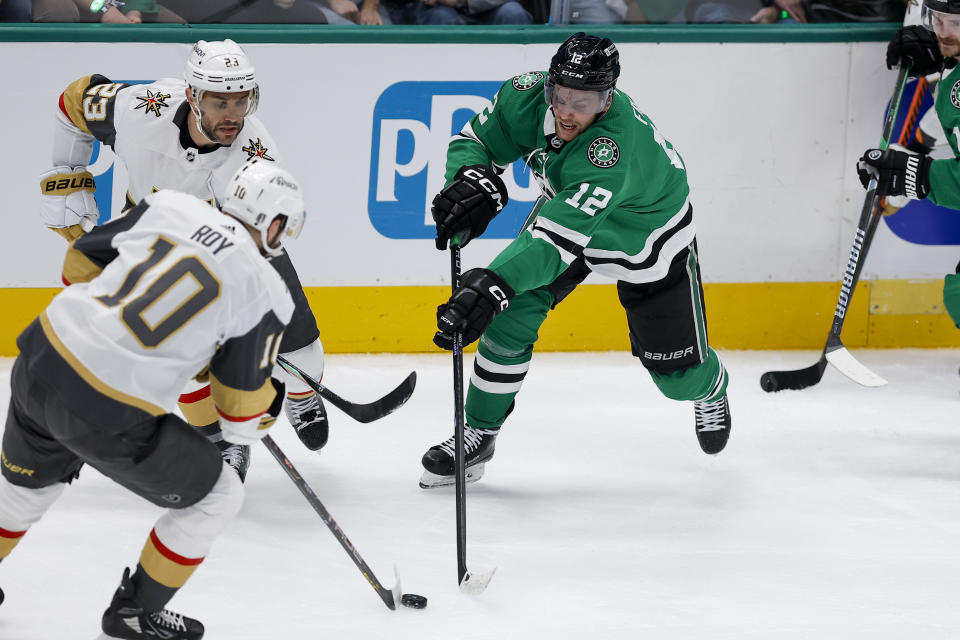 Dallas Stars center Radek Faksa (12) competes for the puck against Vegas Golden Knights center Nicolas Roy (10) and defenseman Alec Martinez (23) during the third period in Game 7 of an NHL hockey Stanley Cup first-round playoff series, Sunday, May 5, 2024, in Dallas. (AP Photo/Brandon Wade)