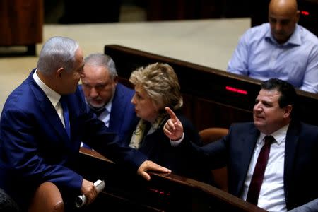 Israeli Prime Minister Benjamin Netanyahu chats with Ayman Odeh, head of the Joint Arab List, in the plenum at the Knesset, Israel's parliament, in Jerusalem December 26, 2018. REUTERS/Ronen Zvulun/Files