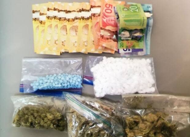 Police say oxycodone and diazepam pills, plus cannabis and cannabis resin, weapons, and cash were seized during a targeted stop in Borden-Carleton on Tuesday. (Submitted by RCMP - image credit)