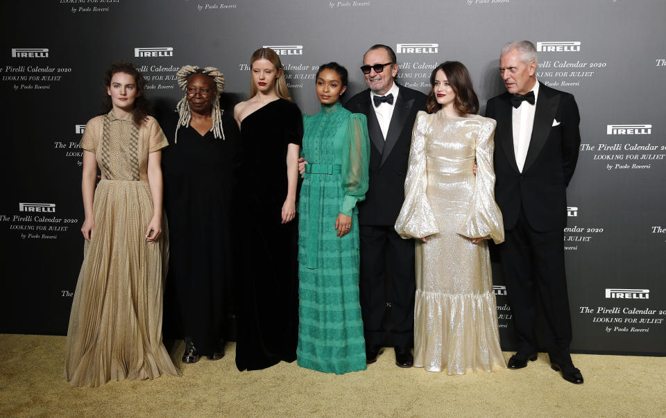 From left, Stella Roversi, American actress Whoopi Goldberg, British model Mia Goth, American model Yara Shahidi, Italian photographer Paolo Roversi, British actress Claire Foy and Pirelli CEO Marco Tronchetti Provera pose for photographers at the 2020 Pirelli Calendar event in Verona, Italy, Tuesday, Dec. 3, 2019. (AP Photo/Antonio Calanni)