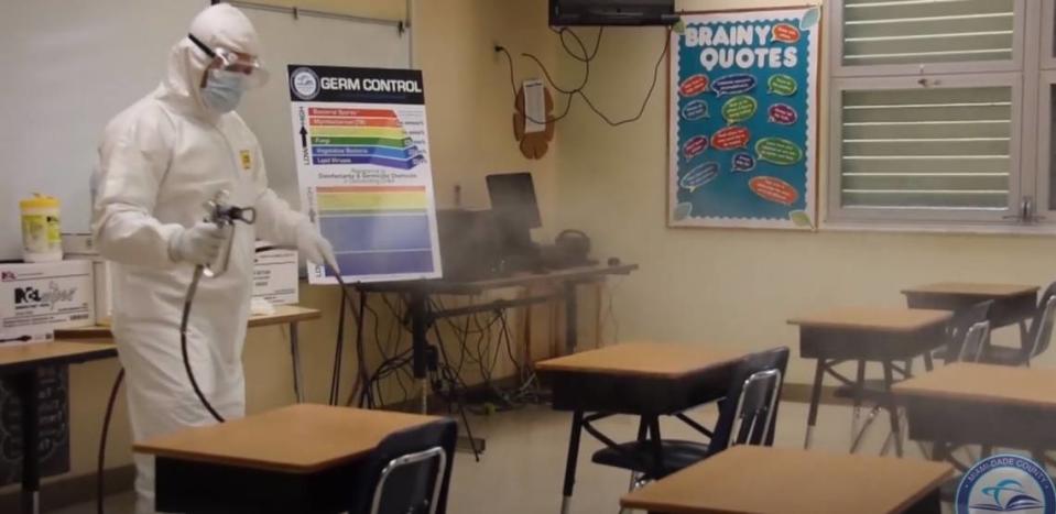 To limit the potential spread of COVID-19 in Miami-Dade County Public Schools, the district imposed various health-safety measures, such as enhanced cleaning of schools and buses. A screen grab of a district video shows a worker disinfecting a classroom.